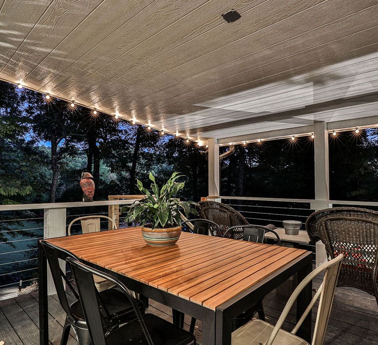 A table and chairs on the patio of a house.