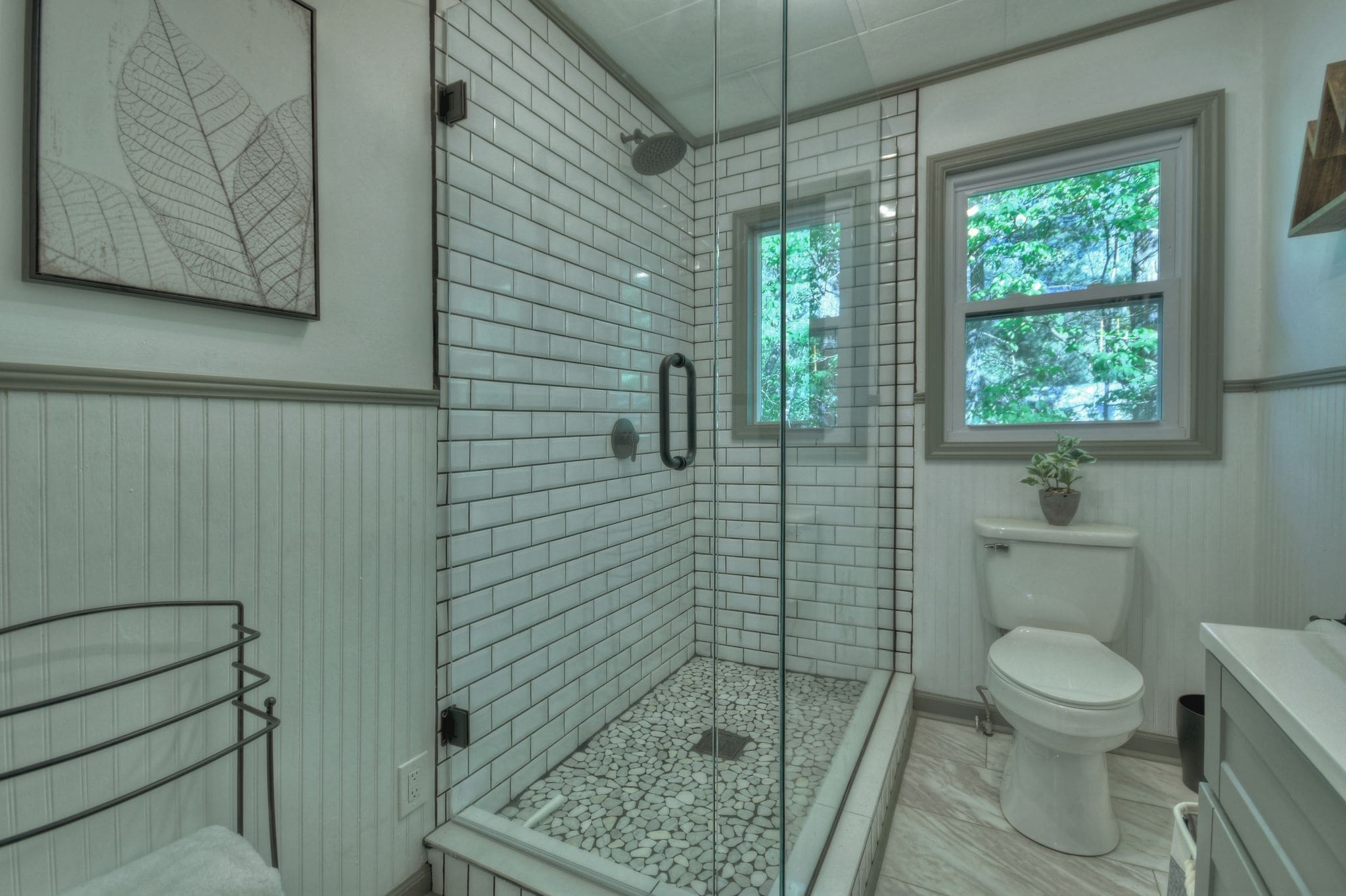 A bathroom with a shower, toilet and tiled floor.