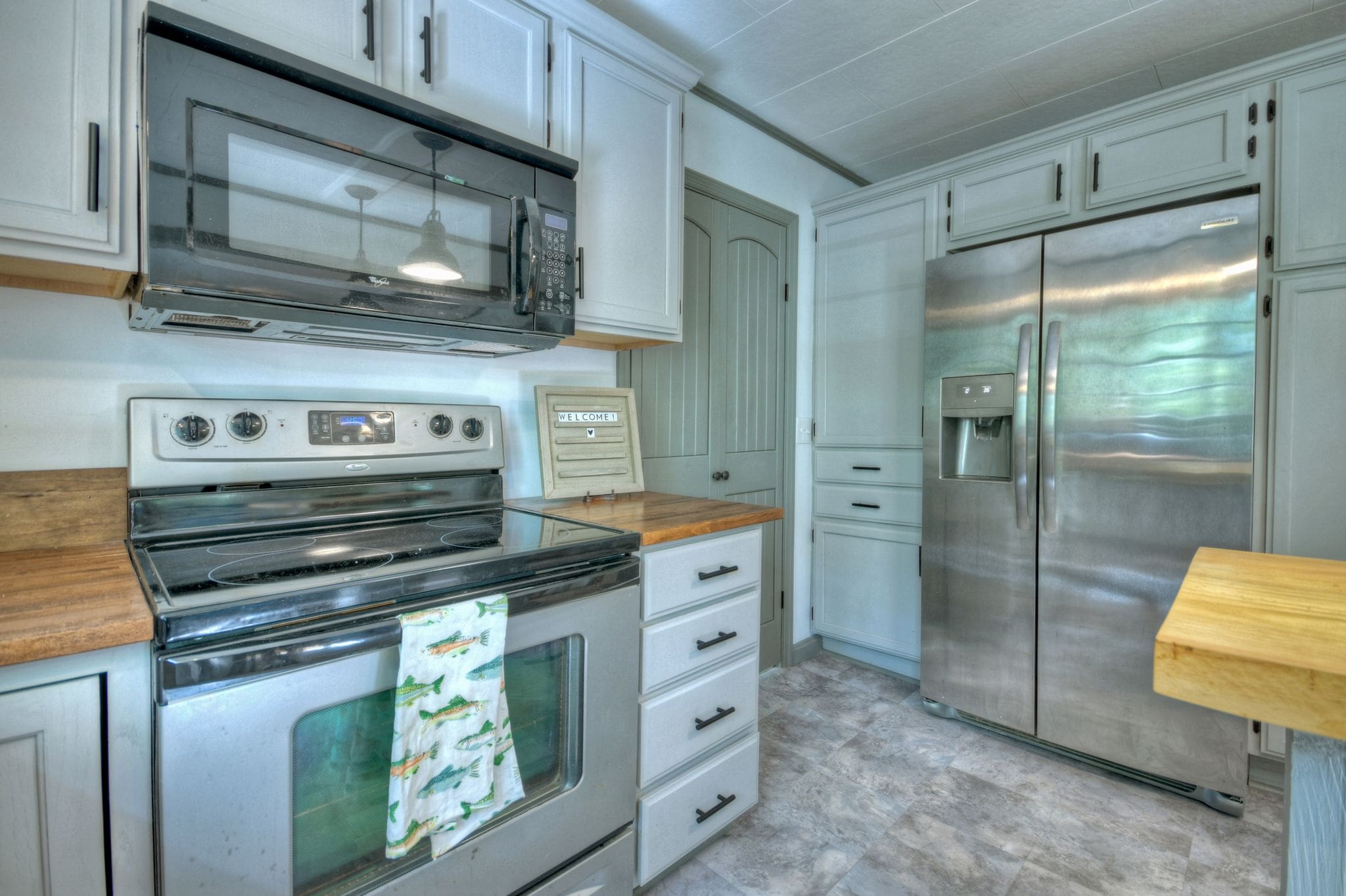 A kitchen with white cabinets and stainless steel appliances.