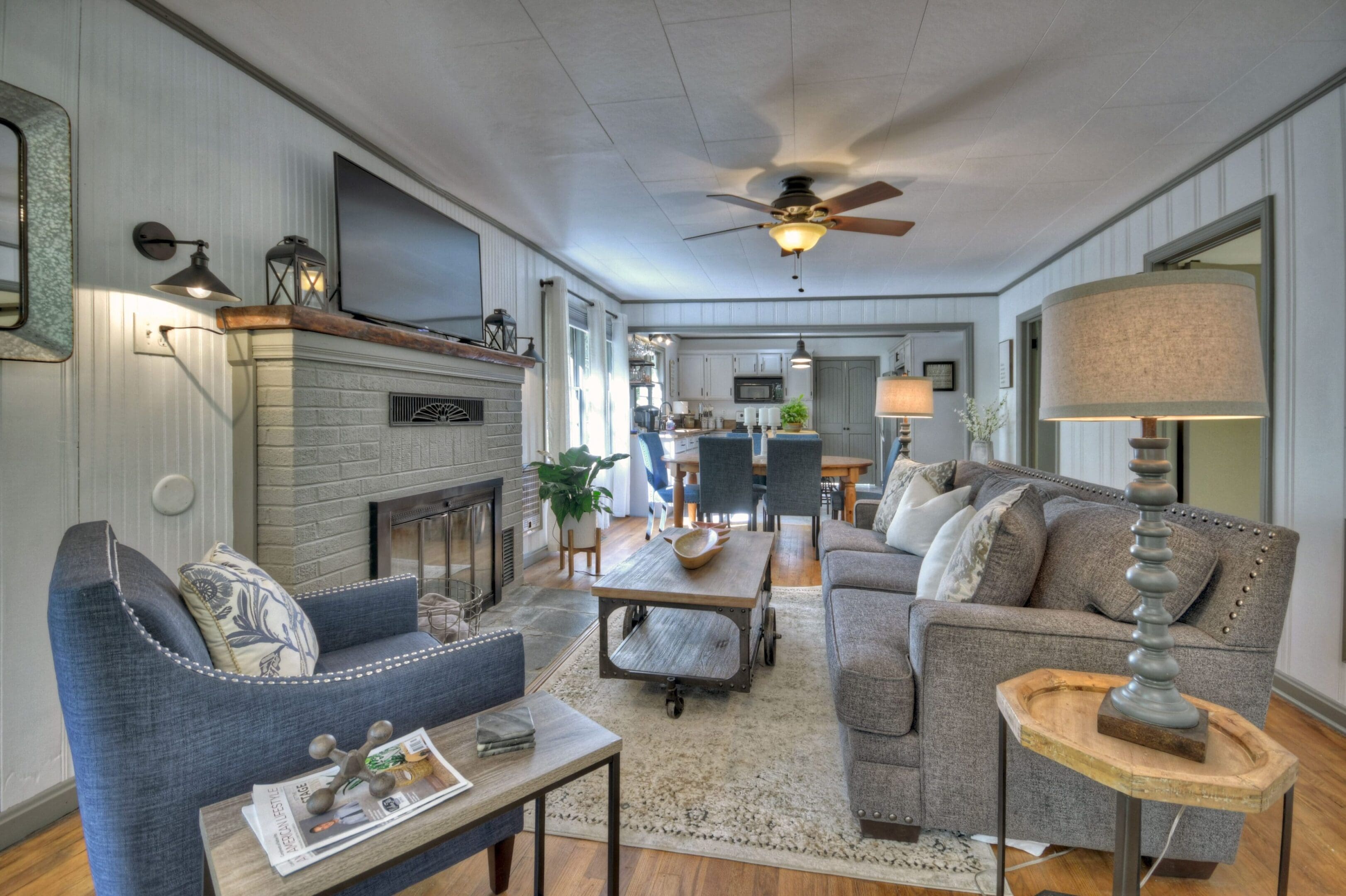 A living room with couches, tables and a fireplace.