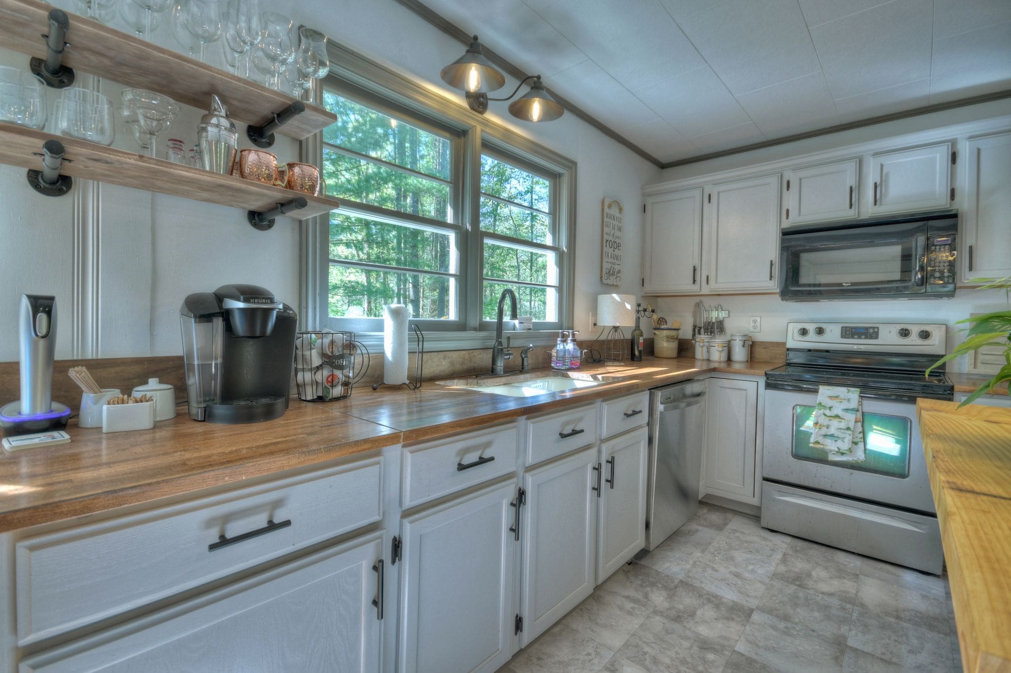 A kitchen with white cabinets and wooden countertops.