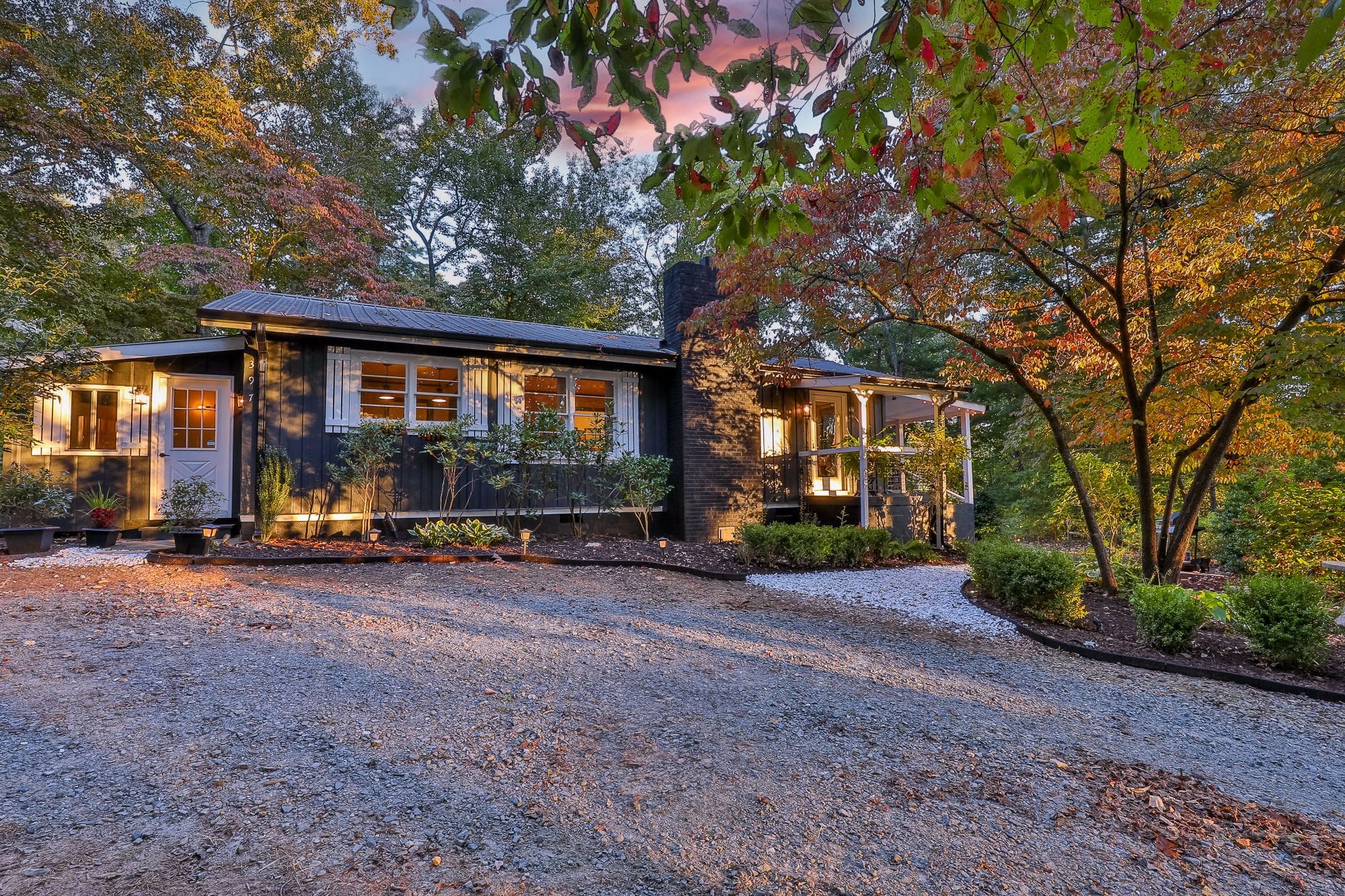 A house with a driveway and trees in the background.