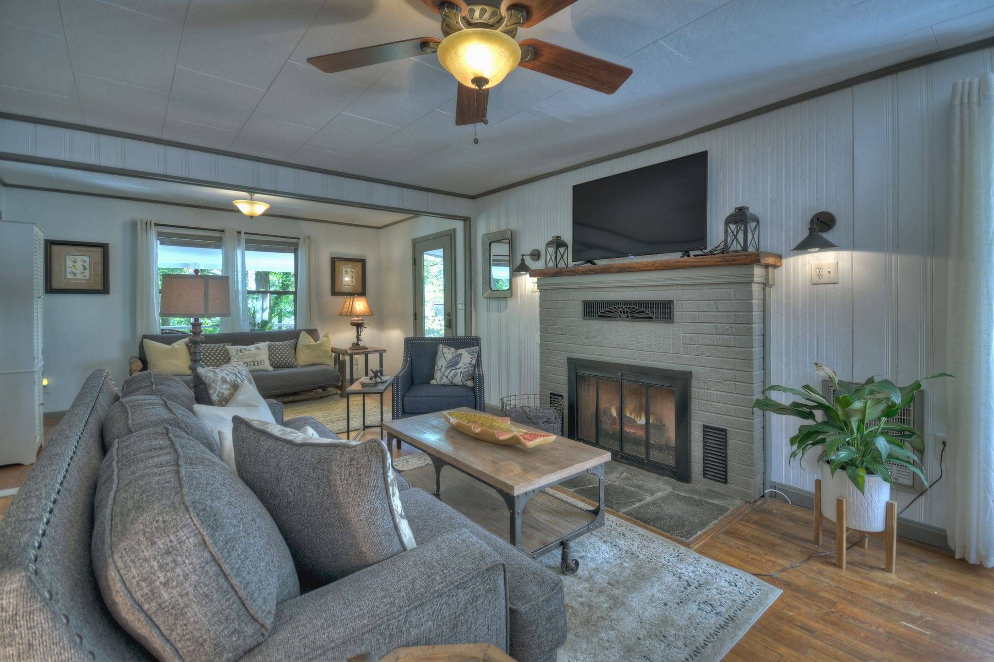 A living room with a couch, table and fireplace.