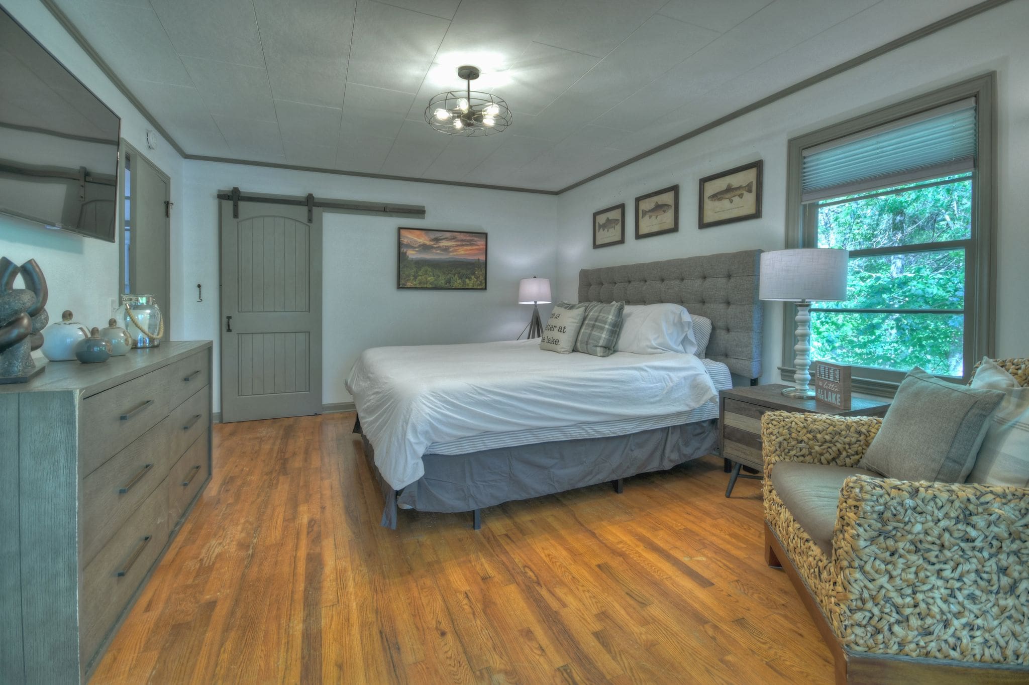 A bedroom with hard wood floors and white walls.